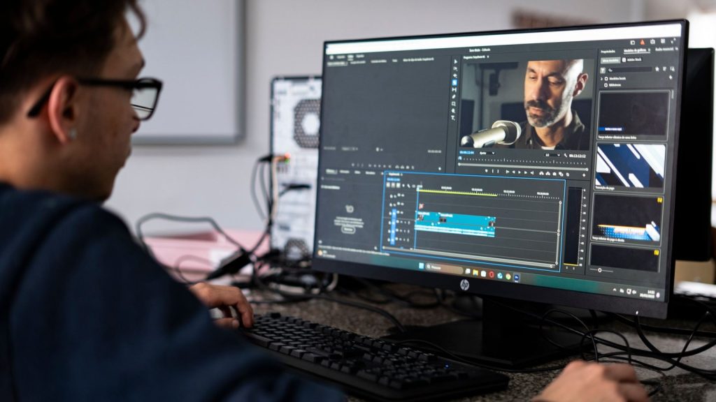 Người dựng video làm việc với phần mềm dựng phim trên màn hình máy tính